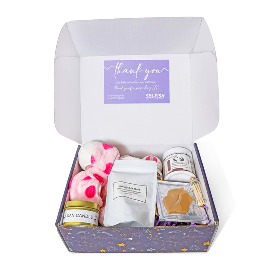 A selection of luxurious self-care products arranged inside a Selfish By Lola self-care gift box